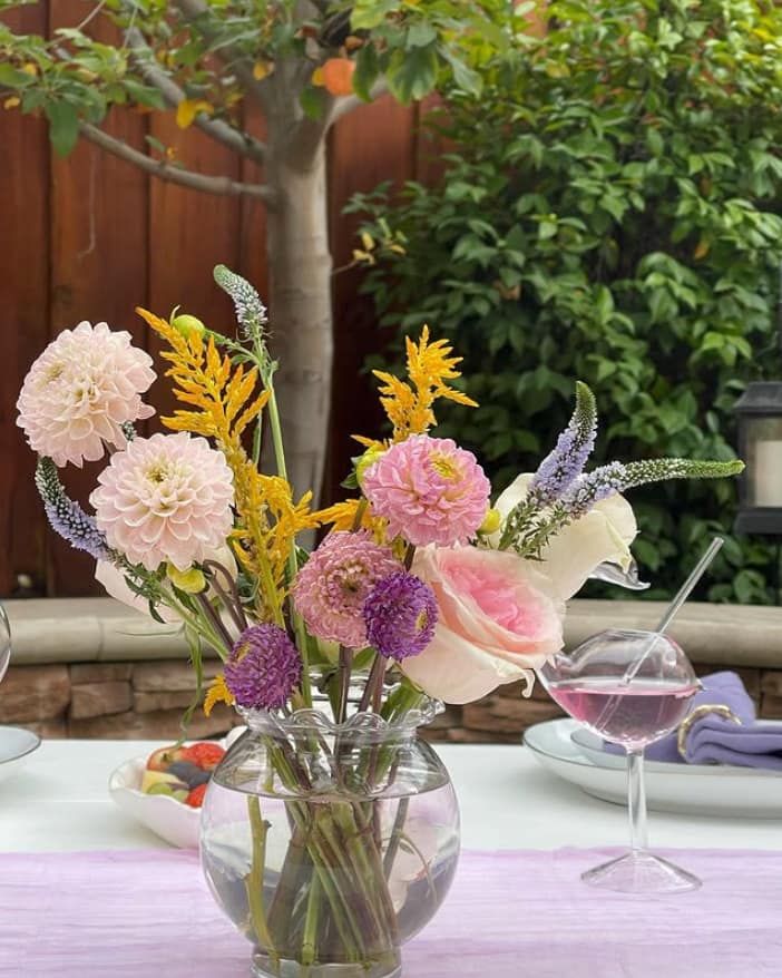 Table center piece of flowers for a backyard event by Mellow Events